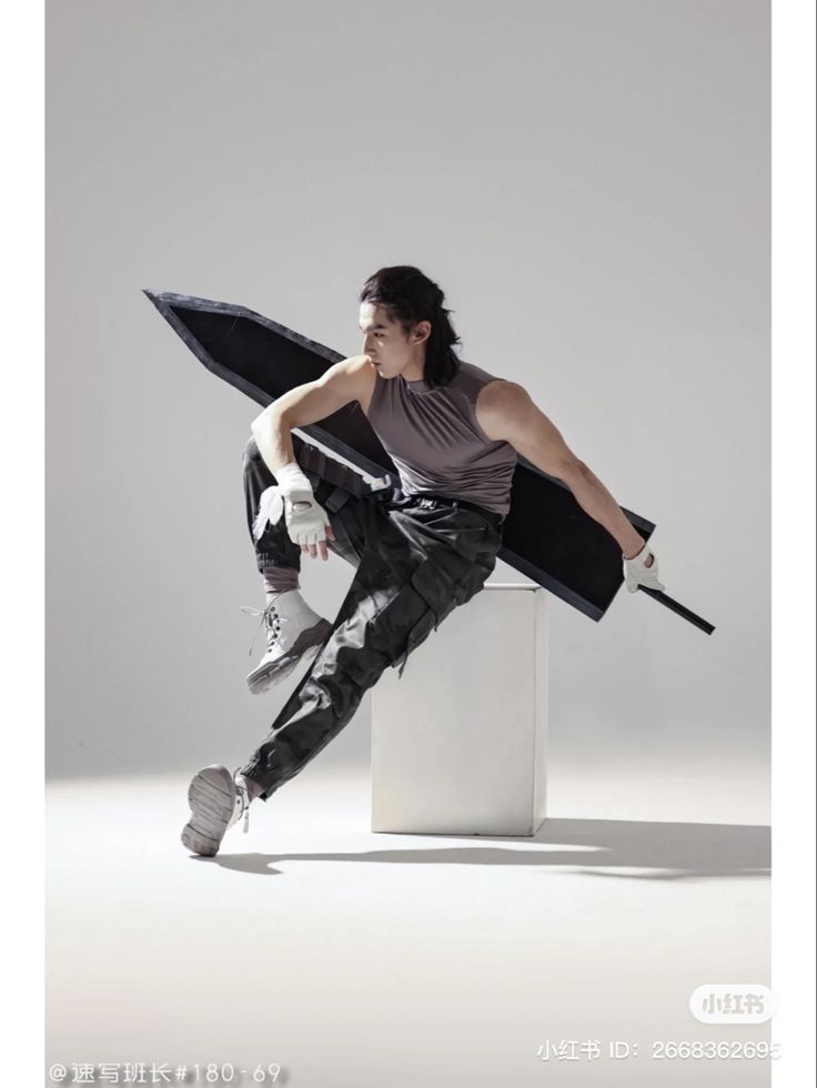 a man in grey shirt and black pants with an umbrella over his head sitting on a white pedestal