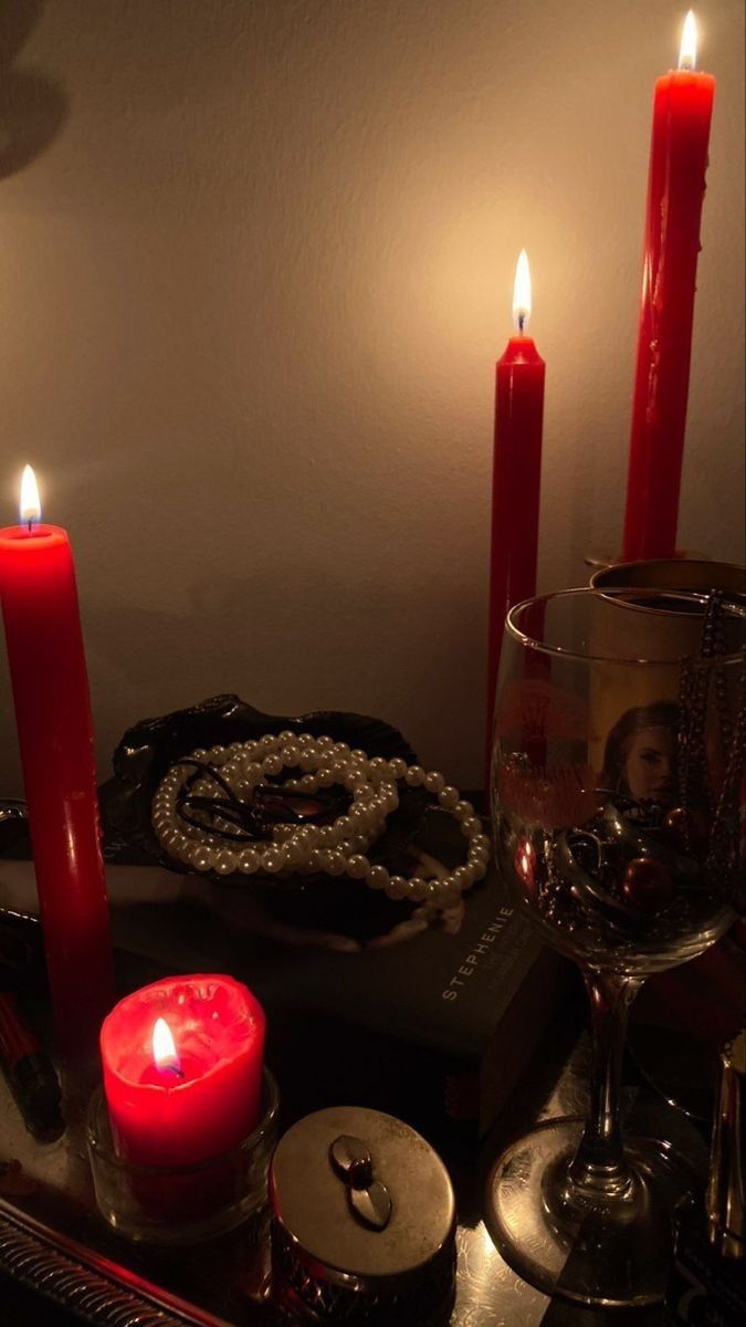 three candles are lit on a table with other items