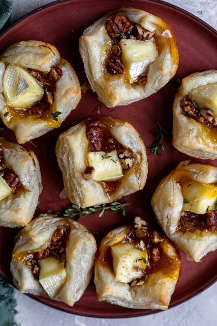 small pastries with meat and cheese are on a red plate