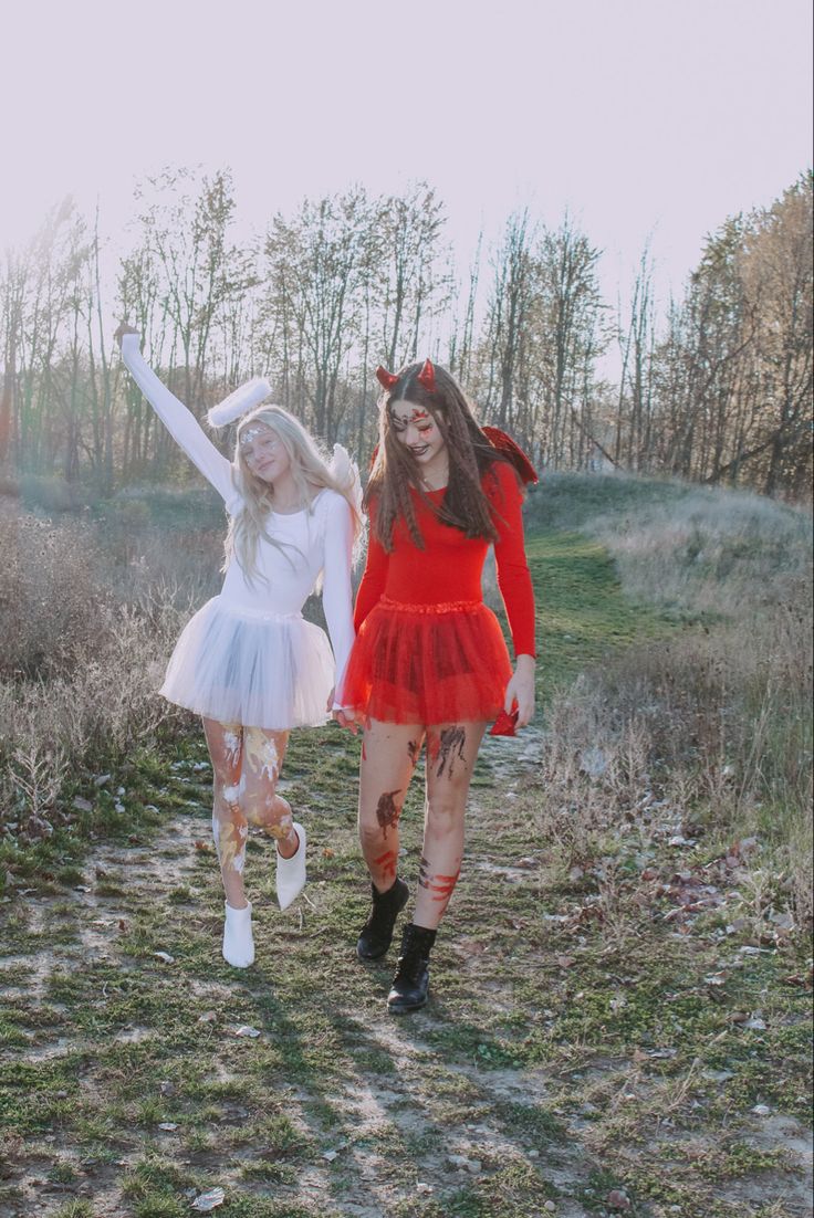 two young women dressed in costumes walking through the woods