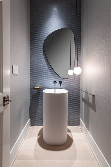 a white sink sitting under a mirror next to a wall mounted faucet in a bathroom