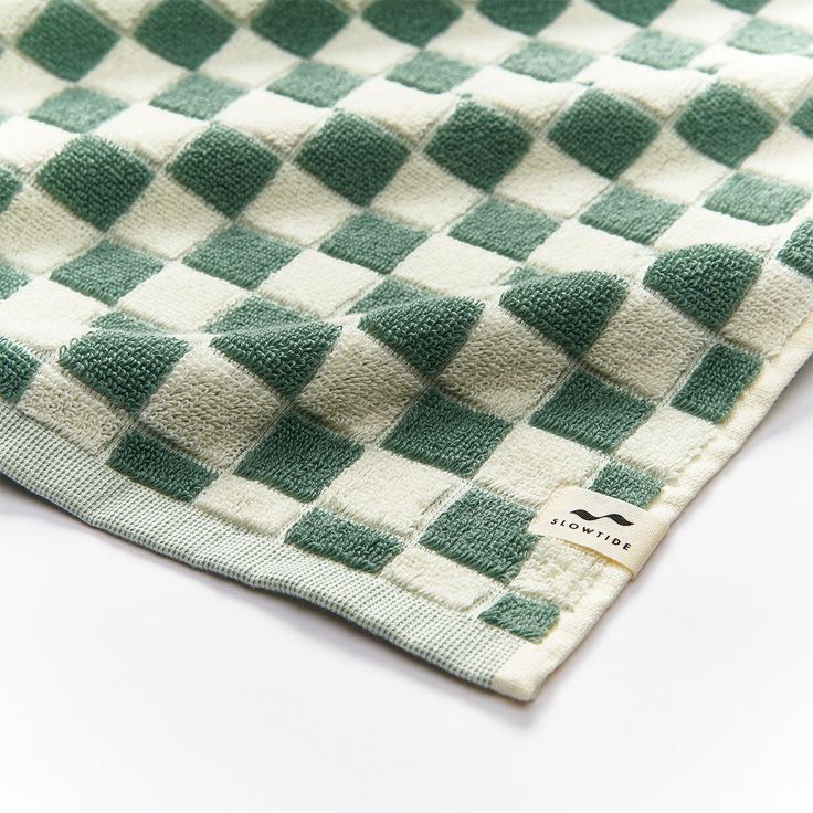 a green and white checkered towel laying on top of a table