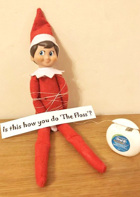 an elf with a sign that says is this how you do the floss?