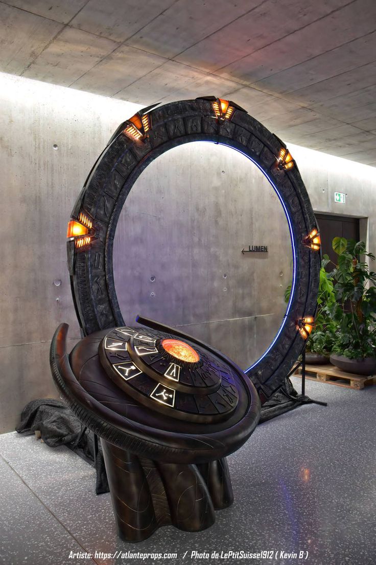 a round mirror sitting on top of a table in front of a giant object with lights