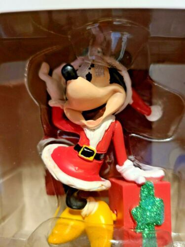 a mickey mouse figurine sitting on top of a christmas present in a box