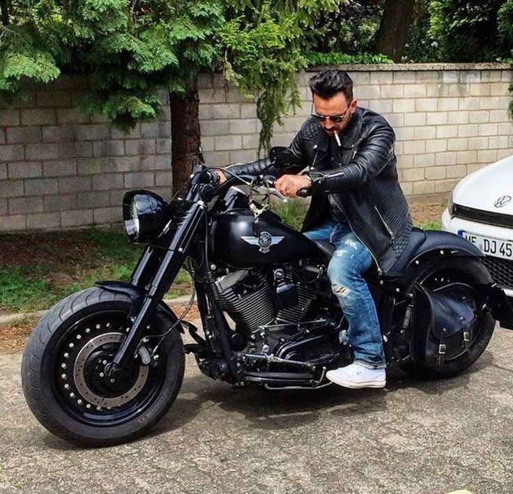 a man sitting on top of a black motorcycle