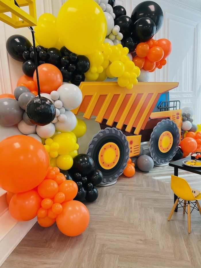 an orange and black tractor balloon decoration in a room