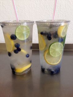 two glasses filled with lemon, blueberries and limeade