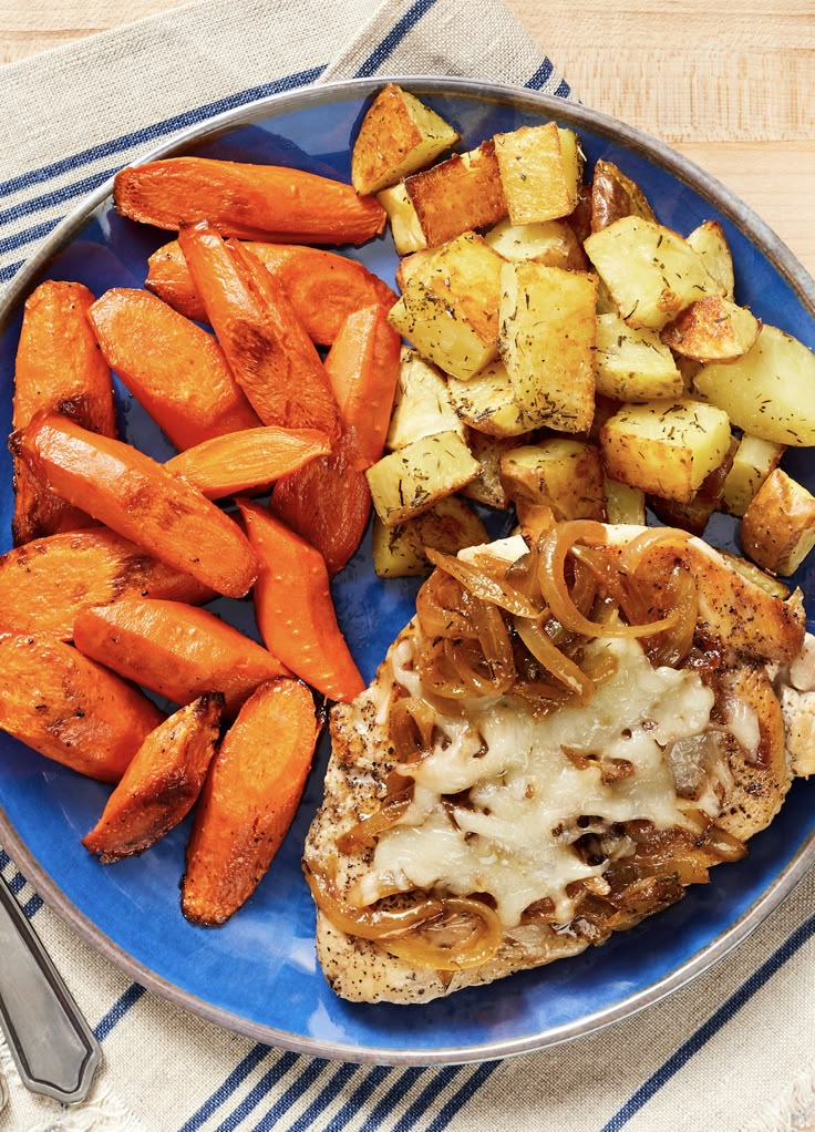 a blue plate topped with meat, potatoes and carrots