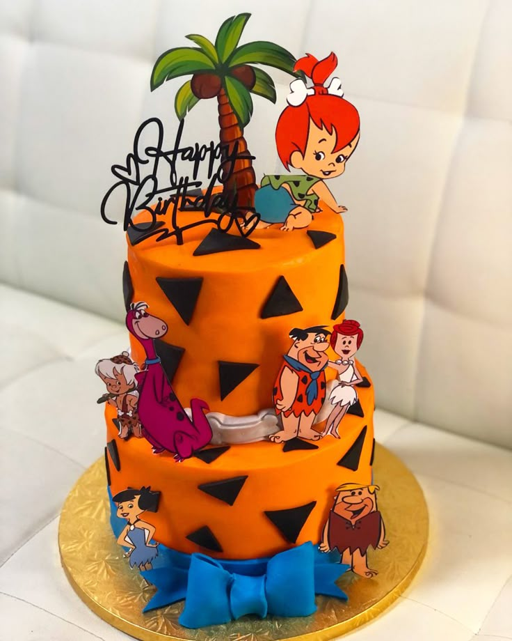 a cake with cartoon characters on it and a palm tree in the middle is sitting on a gold plate