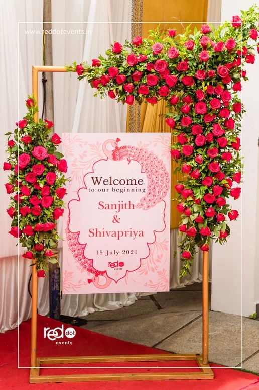 a welcome sign with red roses on it for someone's special occasion at their wedding