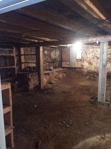 an unfinished basement with exposed walls and shelves