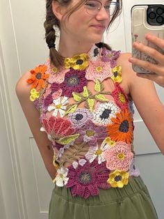 a woman taking a selfie in front of a mirror wearing a flowery top