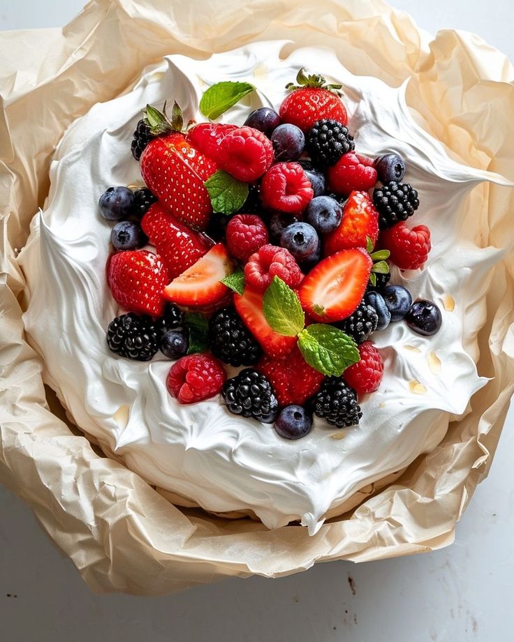 a cake with berries and mint leaves on top