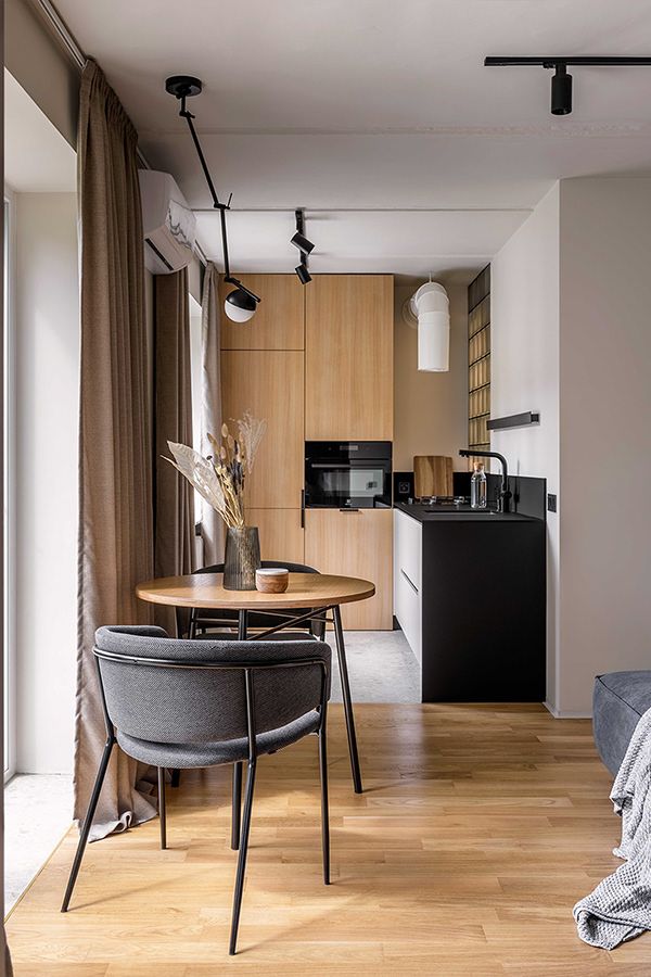 a kitchen and dining area with wood flooring in a modern style home, including an open concept living space