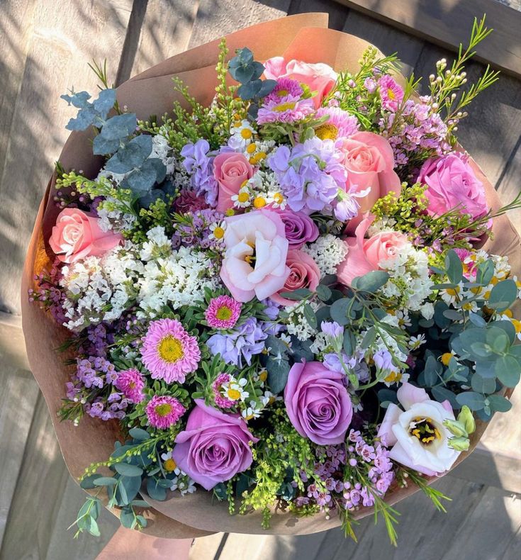 a bouquet of flowers sitting on top of a wooden table