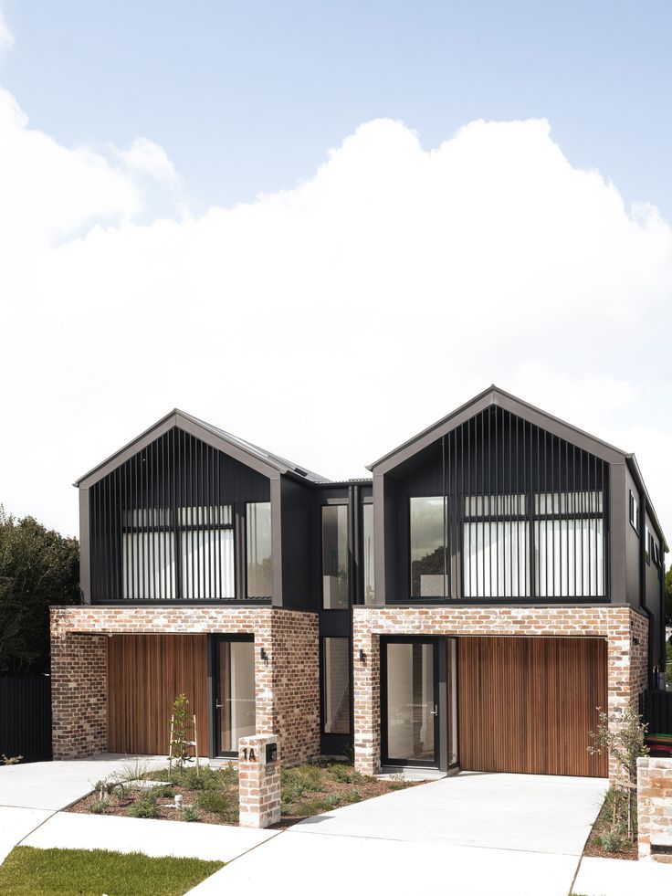 two story brick house with wooden garage doors