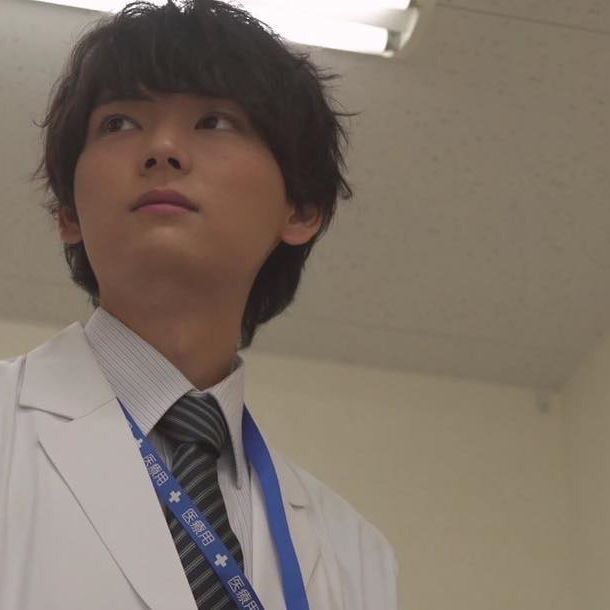 a young man wearing a suit and tie in an office building looking up at the sky