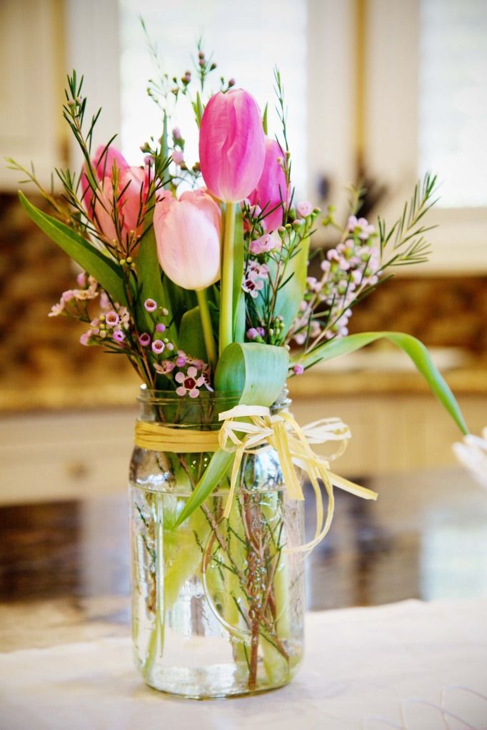 a mason jar filled with flowers on top of a table