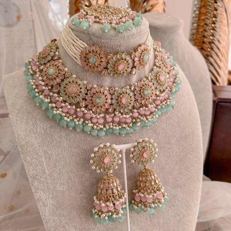 Statement bridal set made with antique plating, champagne crystals, Mint and pink gems. Finished with an abundance on tiny bead detailing in pearl, mint and ombre pink glass drops.  Set comes complete as seen with choker (1 inch wide), necklace(1.5 inch wide, Jhumka earrings (3 inch length) and statement Tikka (2.5 inch length x 2 inch width) Ready to ship with Gift Box. Bridal Survival Kit, Wide Necklace, Pakistani Bridal Jewelry, Indian Wedding Jewelry Sets, Indian Accessories, Indian Bridal Jewelry Sets, Pink And Mint, Bridal Jewellery Design, Double Necklace