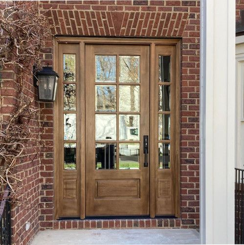 the front door is made of wood and has two sidelights on either side of it