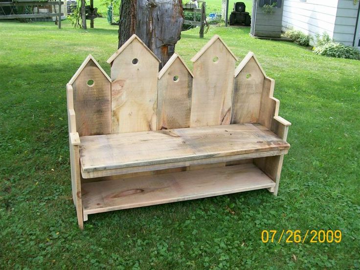 a bench made out of wood with bird houses on it's back and sides