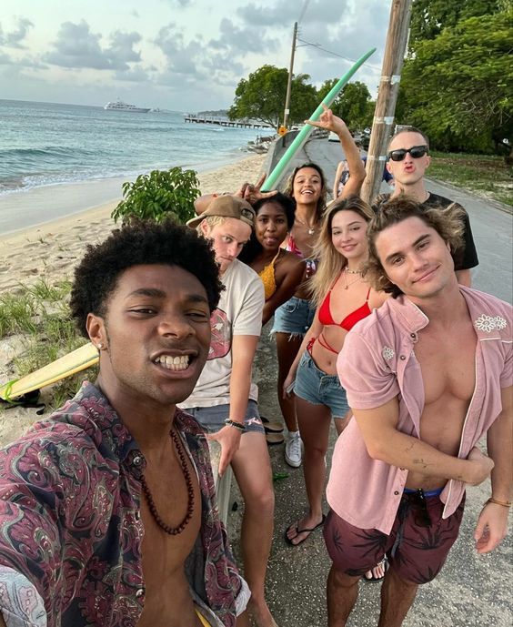 a group of people standing next to each other near the ocean