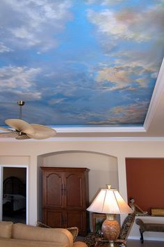 a living room with a sky painted on the ceiling