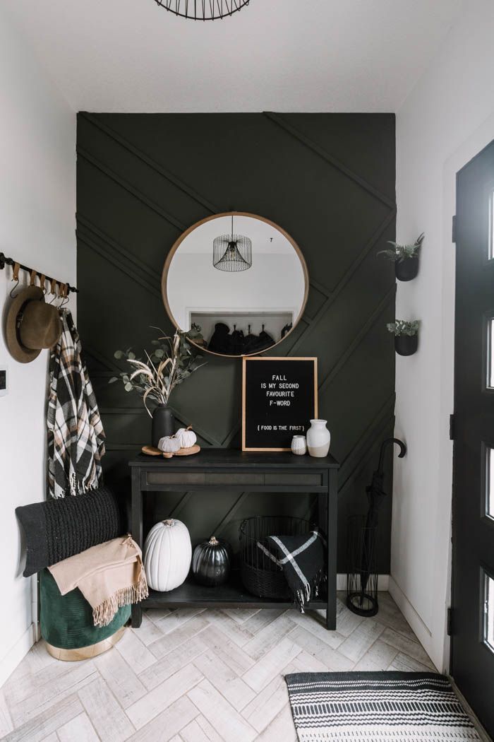 a black and white entryway with a round mirror