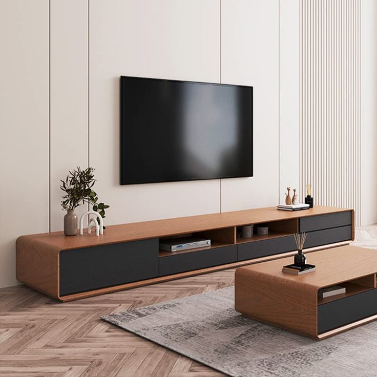 a living room with a large flat screen tv mounted on the wall above it's entertainment center