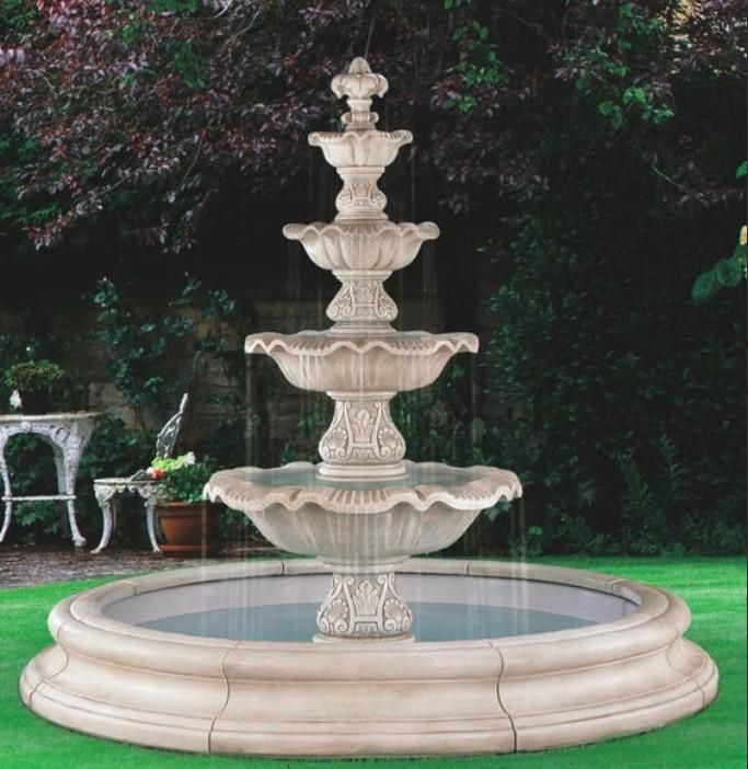 a water fountain sitting on top of a lush green field