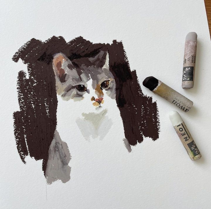 a drawing of a cat with brown hair and three crayons next to it