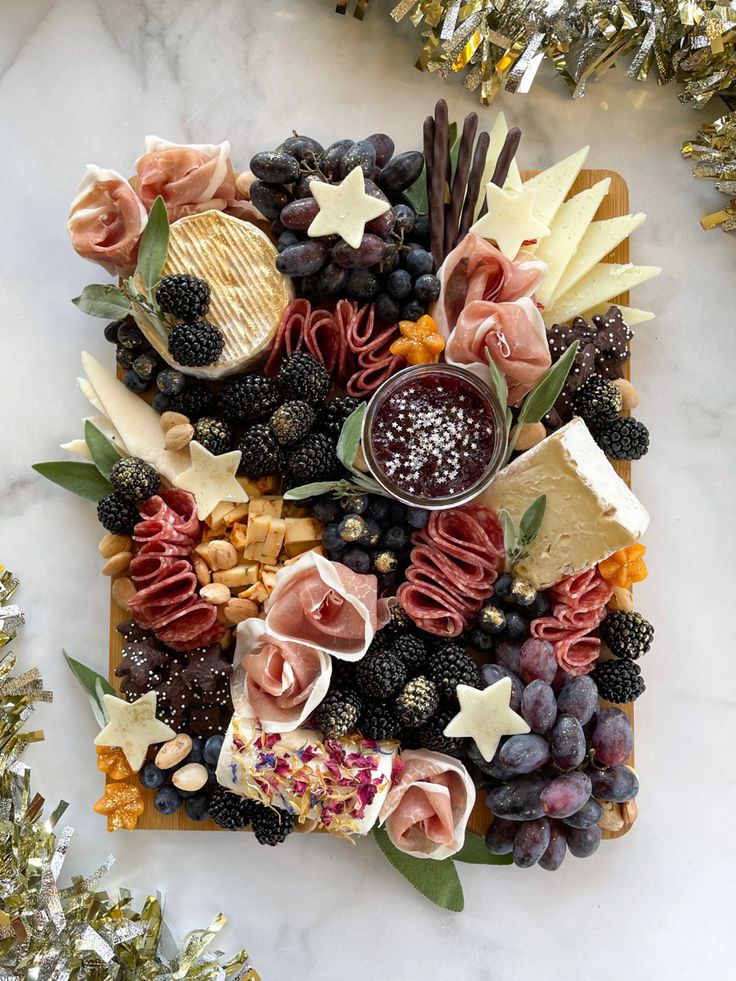 a platter filled with cheese, fruit and crackers on top of a marble counter