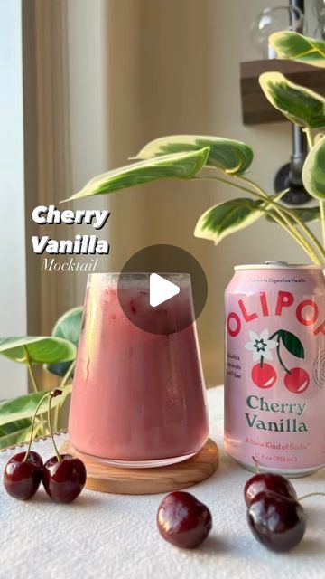 cherry vanilla drink with cherries on table next to potted plant and canister