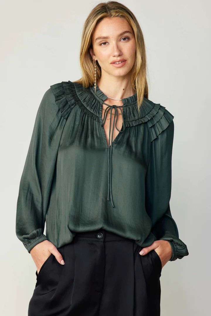 A gathered yoke and layered ruffles at the shoulders heighten the feminine charm of this breezy blouse. It's cut for a loose, relaxed silhouette and features a split neckline, self-tie detailing, and long sleeves with elasticized cuffs.  •Split neckline with self-tie •Gathered yoke •Ruffle trim •Long sleeves with elast Flowy Smocked Bodice Blouse For Fall, Chic Billowy Smocked Top For Fall, Fall Long Sleeve Smocked Top With Ruffle Hem, Casual Ruffled Split Neck Blouse, Chic Ruffled Split Neck Blouse, Chic Split Neck Blouse With Ruffles, Chic Fall Peasant Top With Smocked Cuffs, Chic Peasant Top With Smocked Cuffs For Fall, Fall Feminine Blouse With Smocked Bodice