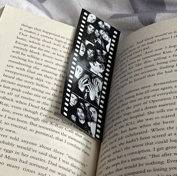 an open book with pictures of people on it and film strips sticking out of the pages