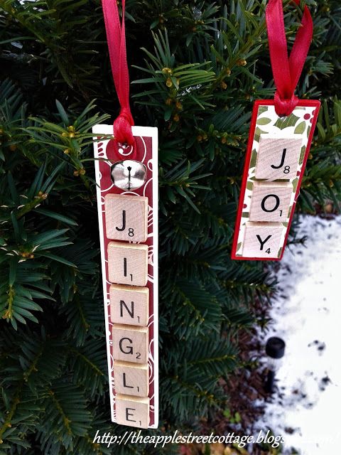 two christmas ornaments hanging from a tree with the word joy and joy spelled on them