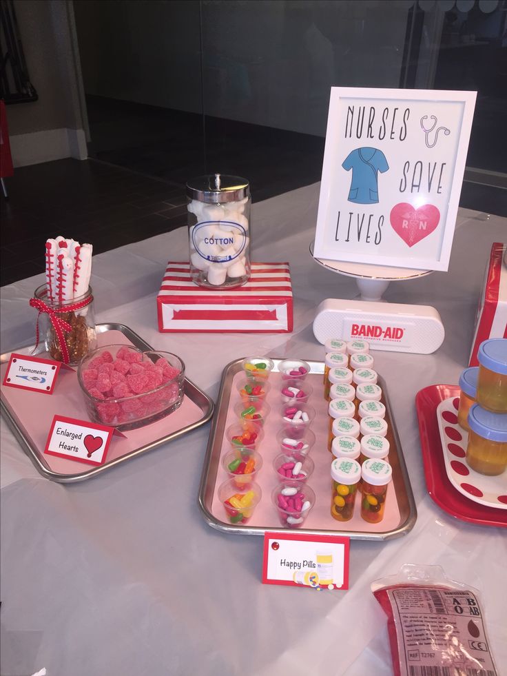 a table topped with trays filled with cupcakes and candy