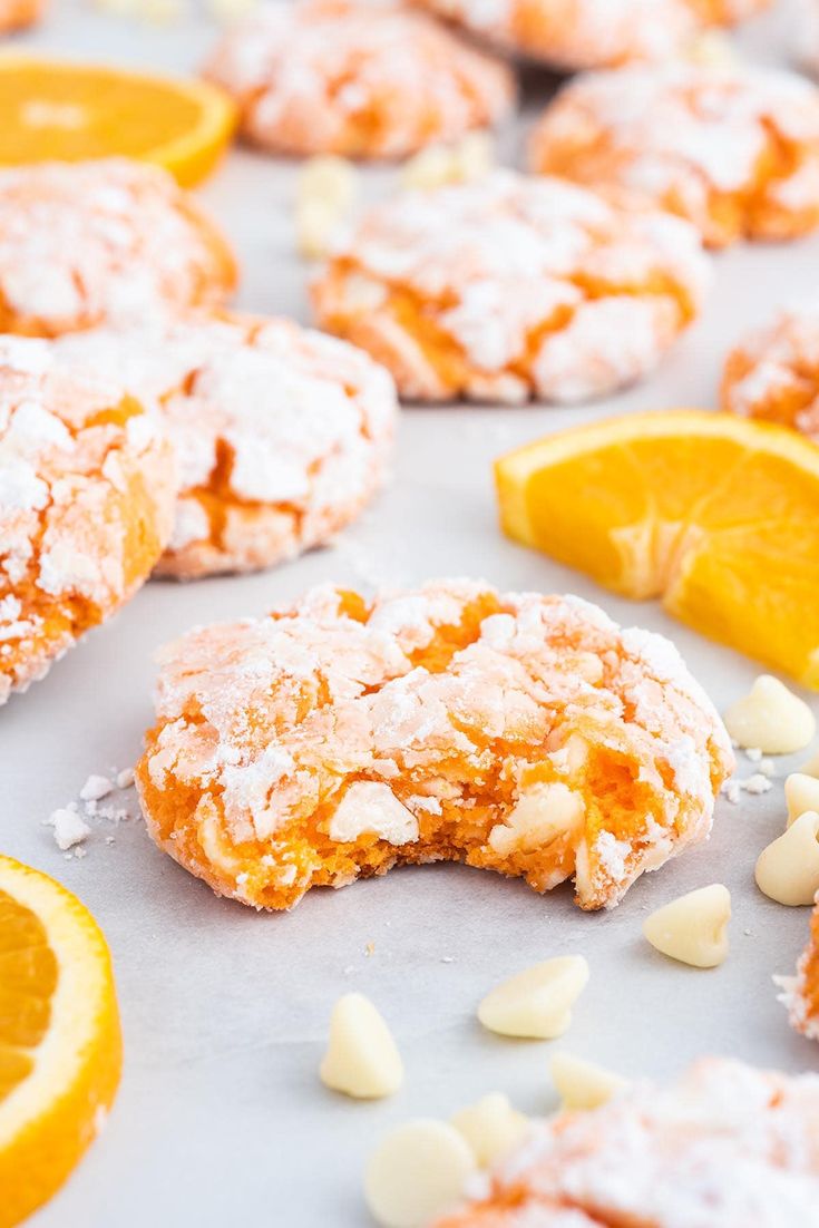 some oranges and cookies on a table with white sugar sprinkled on them