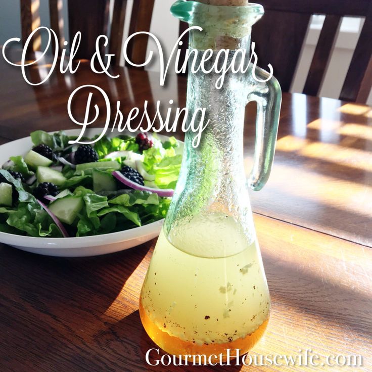 a salad and bottle of dressing sitting on a table with the words oil & vinegar dressing