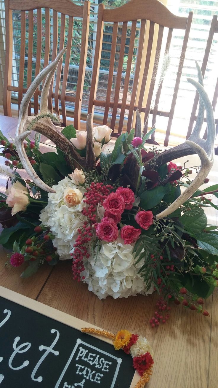 a table with flowers and antlers on it