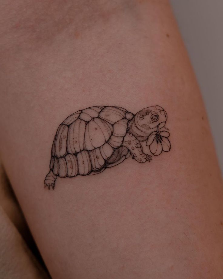 a small turtle tattoo on the right thigh