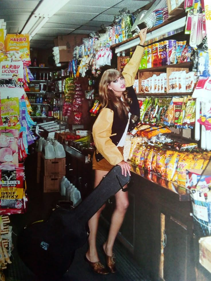 a woman standing next to a luggage bag in a store filled with food and snacks