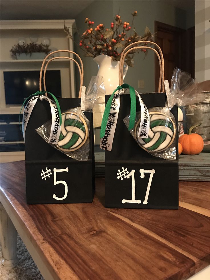 two black bags with white numbers and green ribbons