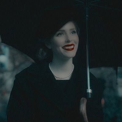 a woman with red lipstick holding an umbrella