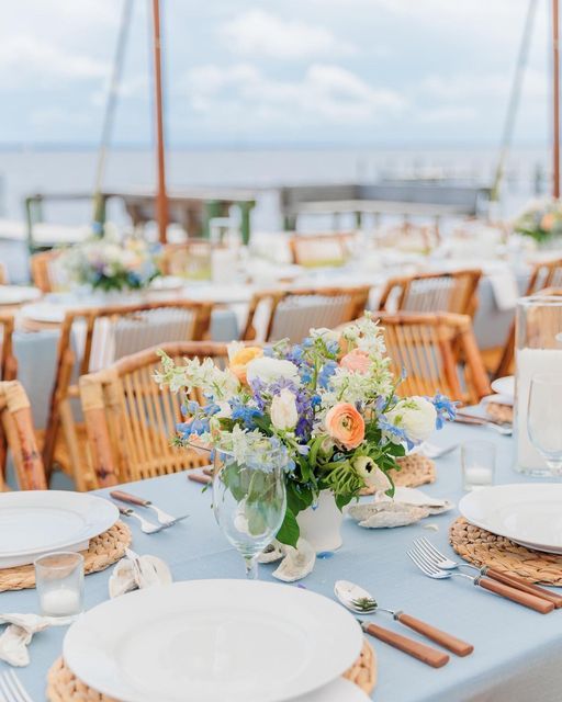 the table is set with flowers and place settings