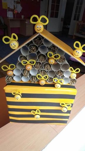 a beehive made out of tin cans with bees on top and yellow handles