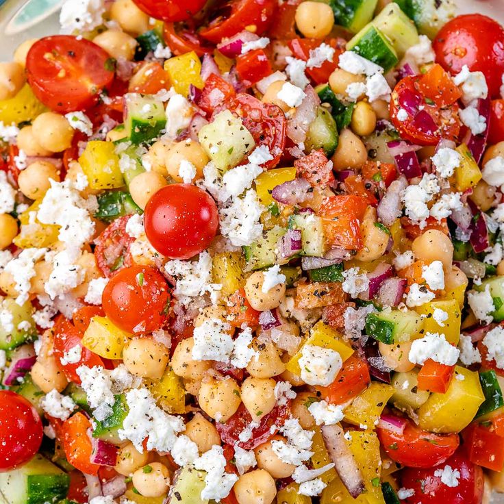 a salad with tomatoes, cucumbers, chickpeas and feta cheese