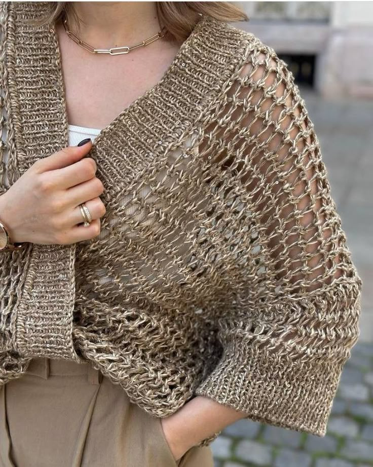 a woman wearing a gold knitted shawl