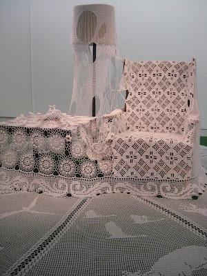 two white crocheted bedspreads and a lamp